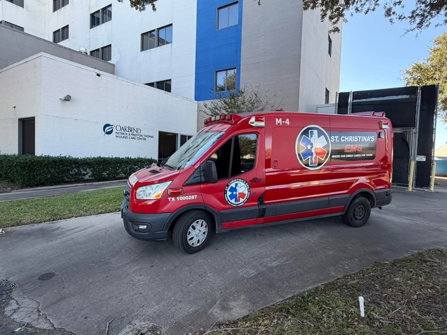 Red St. Christina’s EMS M-4 ambulance parked outside a medical facility